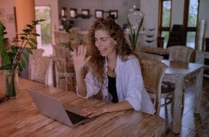 A women is watching at the screen and waving her hand